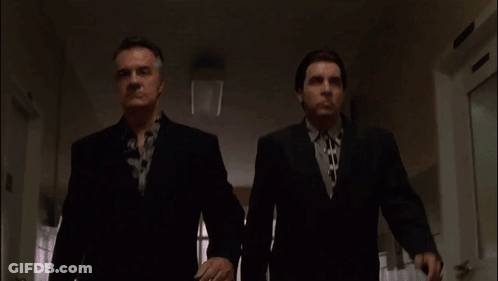 Two Men In Suits And Ties Are Walking Down A Hallway .. GIF