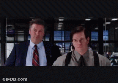 Two Men In Suits And Ties Are Walking In A Dark Room GIF