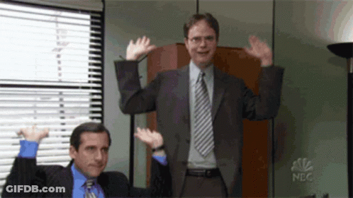 Two Men In Suits And Ties Are Waving Their Hands In The Air In Front Of A Nbc Logo GIF