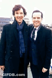 Two Men In Suits And Ties Pose For A Picture Together GIF