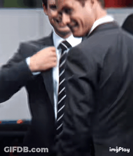 Two Men In Suits And Ties Standing Together GIF