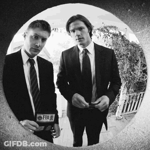 Two Men In Suits And Ties With A Fbi Badge On Their Jacket GIF
