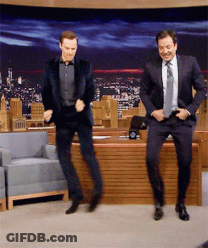Two Men In Suits Are Dancing In Front Of A Desk GIF