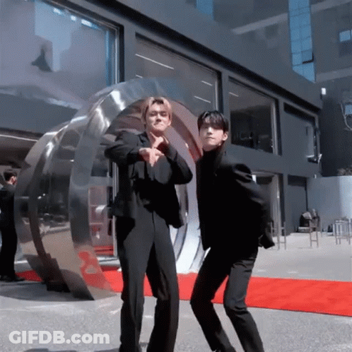 Two Men In Suits Are Dancing On A Red Carpet GIF