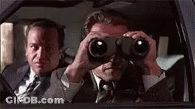 Two Men In Suits Are Looking Through Binoculars In A Car . GIF