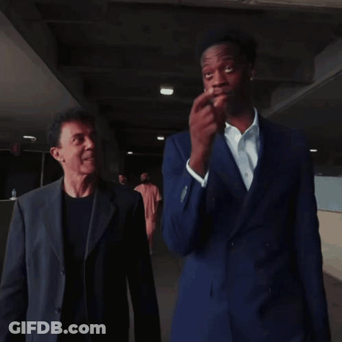 Two Men In Suits Are Standing Next To Each Other GIF