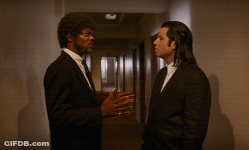 Two Men In Suits Are Talking In A Hallway With The Words It Ain T The Same F * Kin Ballpark Above Them GIF