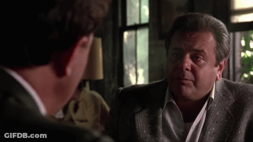 Two Men In Suits Are Talking To Each Other In A Living Room . GIF