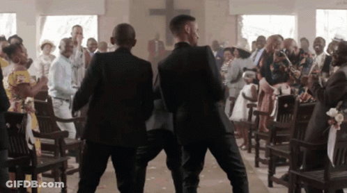Two Men In Suits Are Walking Down A Church Aisle GIF