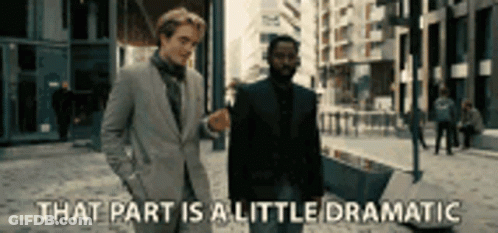 Two Men In Suits Are Walking Down A Street And One Of Them Is Saying That Part Is A Little Dramatic . GIF