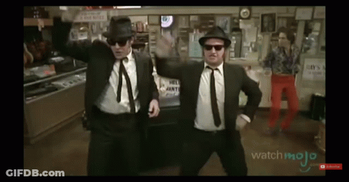 Two Men In Suits Dancing In Front Of Hill Joint Sign GIF