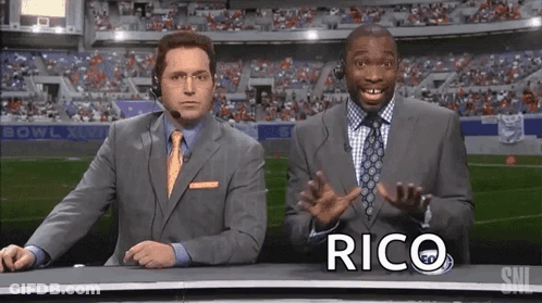 Two Men In Suits In Front Of Stadium Rico GIF