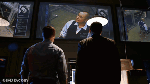 Two Men In Suits One Wearing James Name Tag GIF