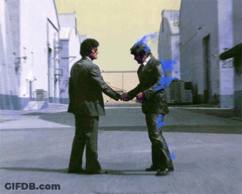 Two Men In Suits Shake Hands On A Street GIF