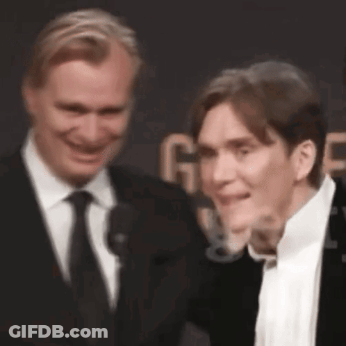 Two Men In Suits Smiling On Red Carpet GIF