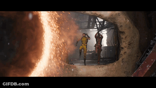 Two Men In Suits Standing In Front Of Fire GIF