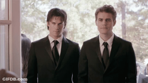 Two Men In Suits Standing Next To Each Other GIF
