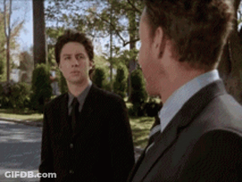Two Men In Suits Standing Together GIF