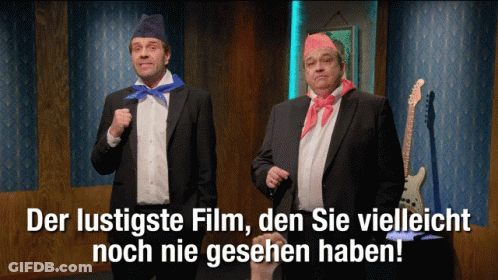 Two Men In Suits Standing Together With Der Lustigste Film Den Sie Vielleicht Noch Nie Gesehn Ha GIF