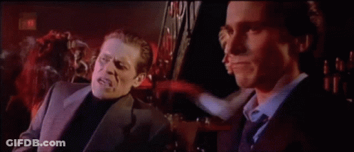 Two Men In Suits Talking In Dark Room GIF