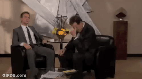 Two Men In Suits Talking In Living Room GIF