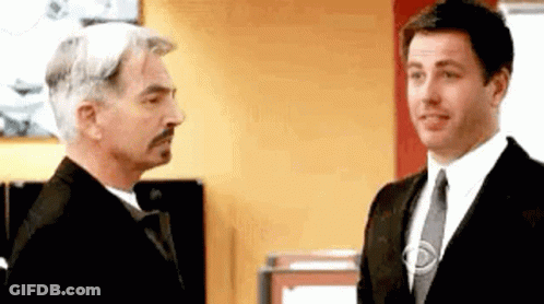Two Men In Suits Talking In Office GIF