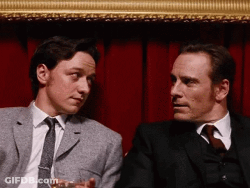 Two Men In Suits Talking One Holding Wine GIF
