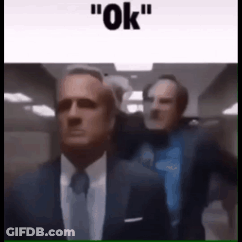 Two Men In Suits Walking Down Hallway Saying Ok GIF