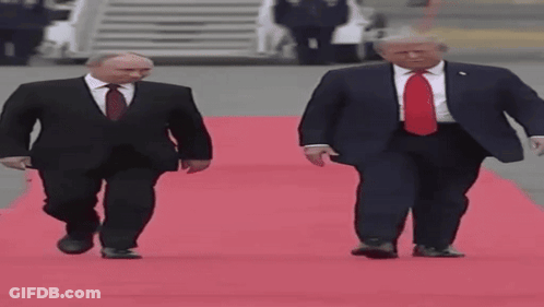 Two Men In Suits Walking On Red Carpet GIF