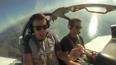 Two Men In Sunglasses And Headphones In Plane GIF