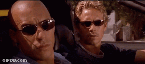 Two Men In Sunglasses Looking At Each Other In Car GIF