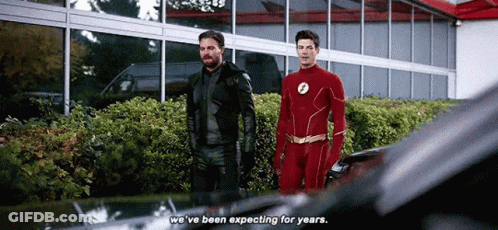 Two Men In Superhero Costumes Are Standing Next To Each Other And Talking . GIF