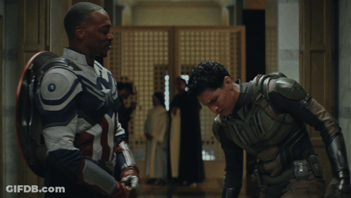 Two Men In Superhero Costumes Standing Together GIF