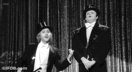 Two Men In Tuxedos And Top Hats On Stage GIF