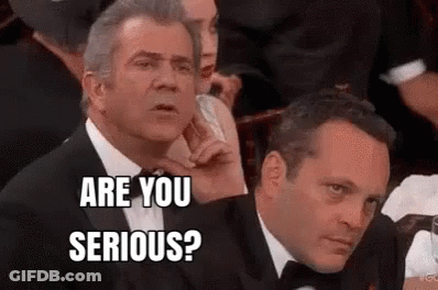 Two Men In Tuxedos Are Sitting Next To Each Other In A Crowd And One Of Them Is Asking The Other If He Is Serious . GIF