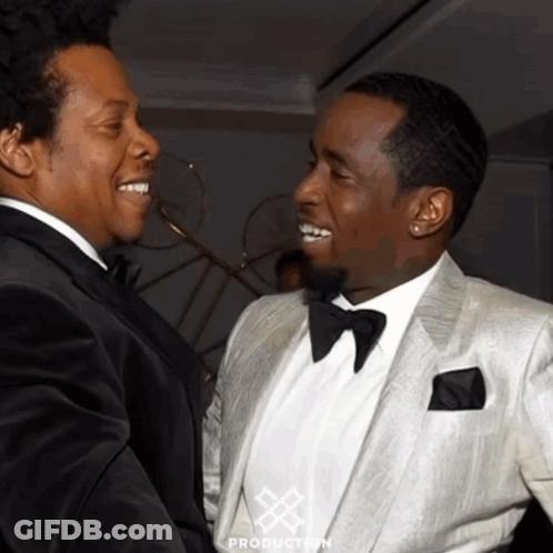 Two Men In Tuxedos Are Standing Next To Each Other And The Word Production Is On The Bottom Of The Picture GIF