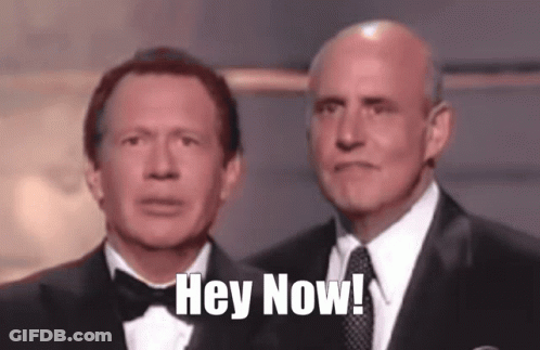 Two Men In Tuxedos Are Standing Next To Each Other With The Words Hey Now Written On Their Faces GIF