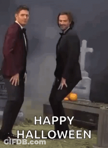 Two Men In Tuxedos Dancing At Cemetery Saying Happy Halloween GIF