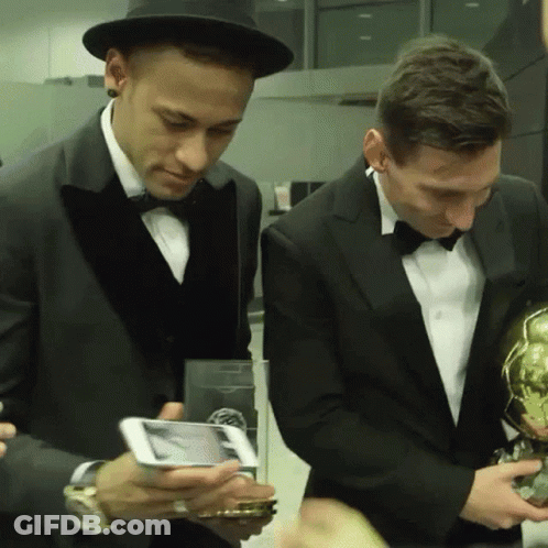 Two Men In Tuxedos Looking At Cell Phone GIF