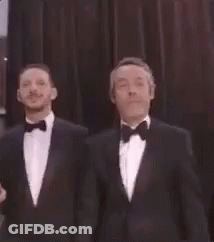 Two Men In Tuxedos Standing GIF