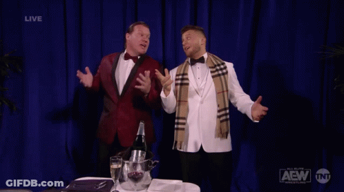 Two Men In Tuxedos With Blue Curtain Saying Live GIF