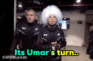 Two Men In Ufc Jackets Are Walking In A Room With The Words " Its Umar 'S Turn " On The Bottom GIF