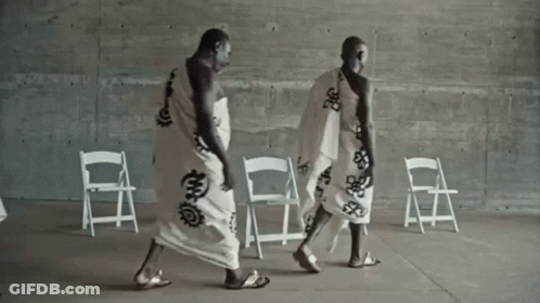 Two Men In White Robes Walking GIF