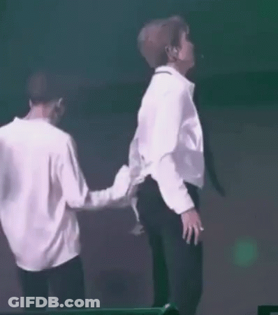 Two Men In White Shirts And Black Pants Dancing In Front Of Green Light GIF