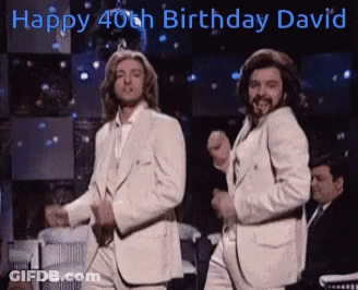 Two Men In White Suits Dancing In Front Of Happy 40Th Birthday David Sign GIF
