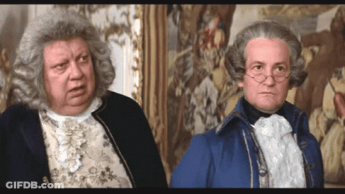 Two Men In Wigs Standing Next To Each Other GIF