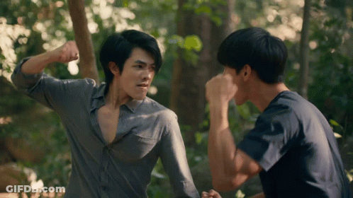Two Men In Woods One Holding Fist Up GIF