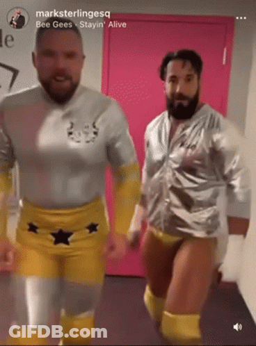 Two Men In Wrestling Outfits Are Dancing In Front Of A Pink Door With The Words " Bee Gees Stayin Alive " On The Bottom GIF