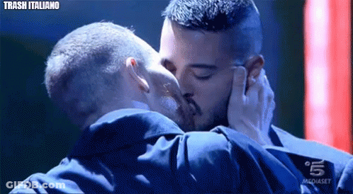 Two Men Kissing In Front Of Mediaset Sign GIF