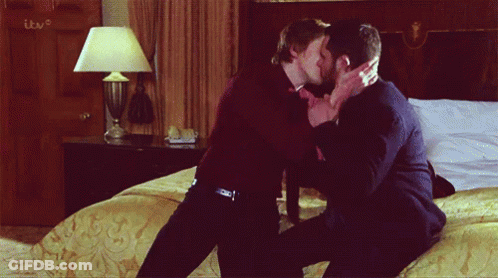 Two Men Kissing In Front Of TV GIF